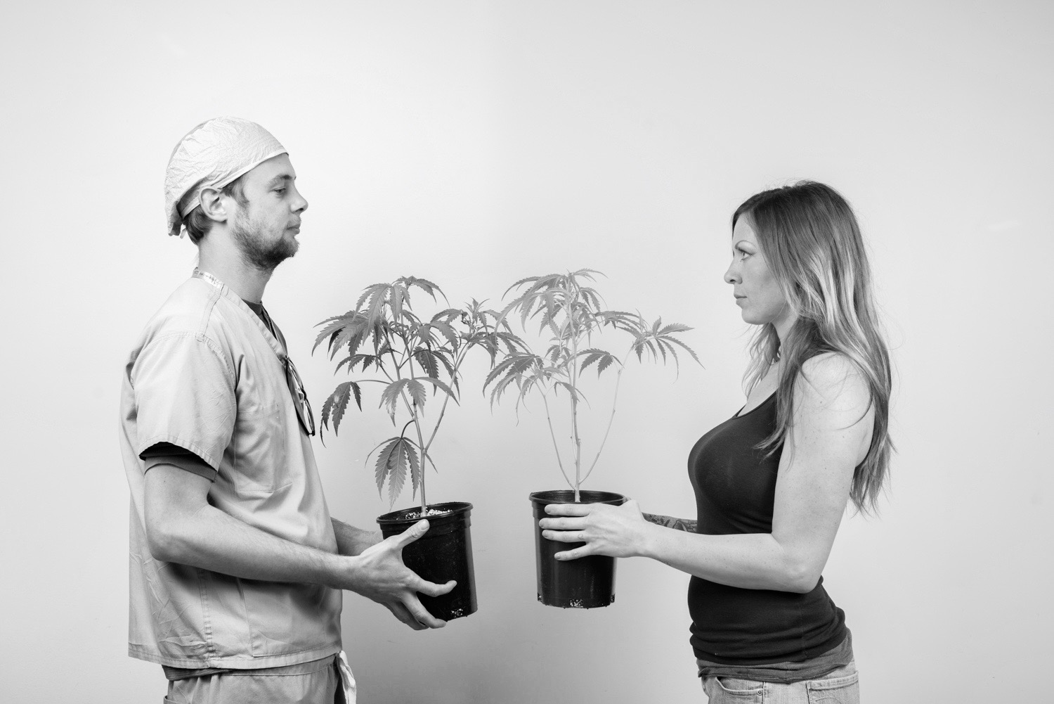 Man And Woman Holding Cannabis Plants